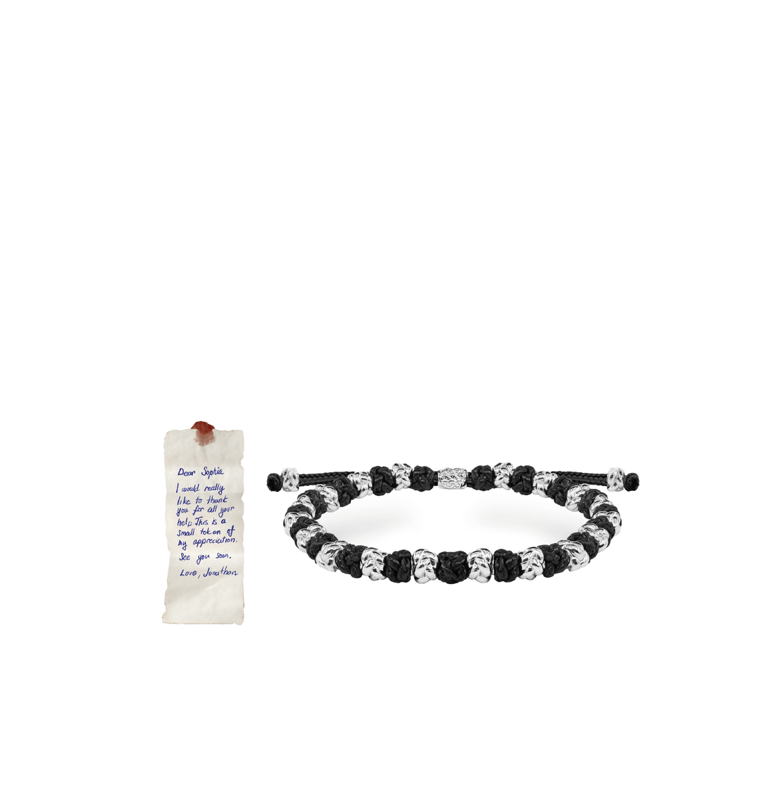 Handwritten note beside a knotted silver bracelet